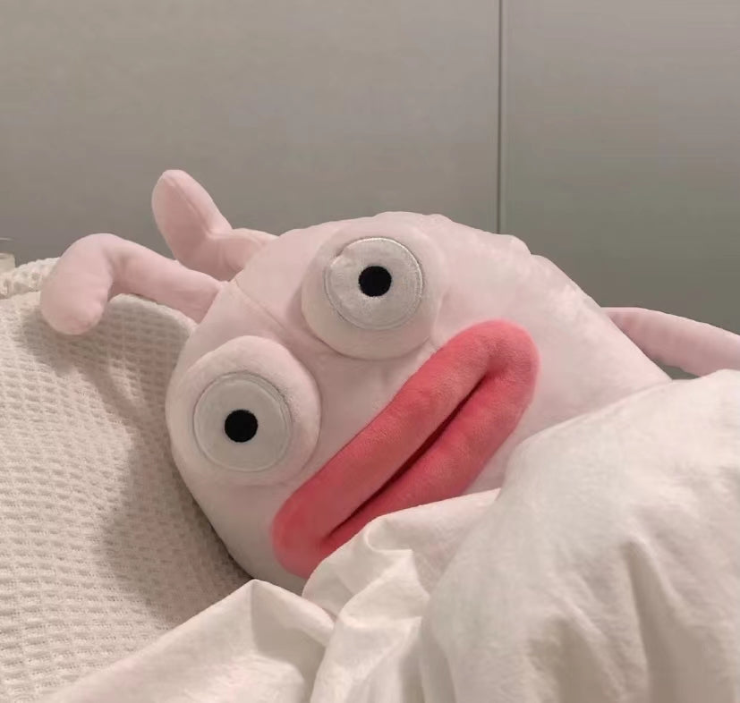 Plush toy with a wide open mouth and large eyes on a neutral background